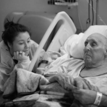Emma sits at the bedside of her Grandpa's hospital bed. He was a disabled veteran and taught her the importance of finding strength in her story.